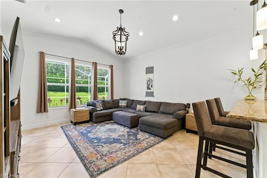 Living area with light tile patterned floors, lofted ceiling, crown molding, and recessed lighting