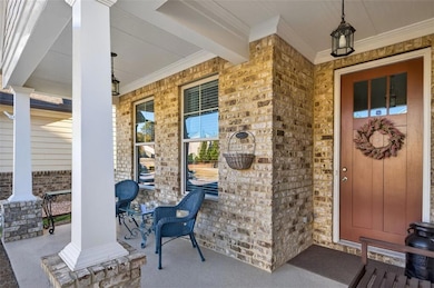 Property entrance with covered porch and brick siding