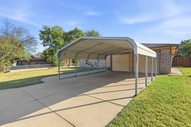 View of parking / parking lot featuring a garage and a carport