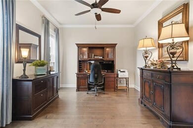 Home office with ornamental molding, light wood-style floors, and ceiling fan
