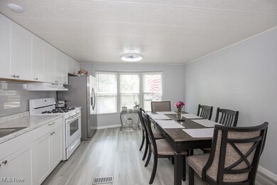 Dining space with light wood-style flooring, baseboards, and a textured ceiling