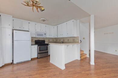 Kitchen featuring tasteful backsplash, tile counters, white appliances, and white cabinetry
