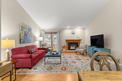 Living area featuring light wood-style floors and a fireplace with raised hearth