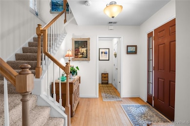 Foyer entrance featuring stairway, visible vents,