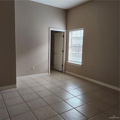 Empty room with light tile patterned floors and baseboards