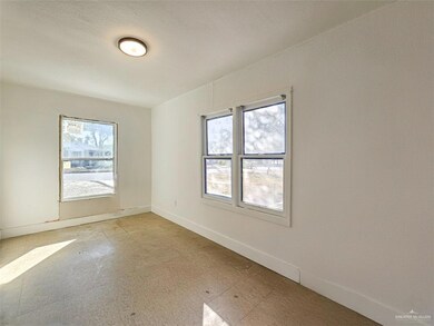 Unfurnished room featuring light flooring and baseboards