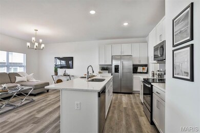 Kitchen featuring stainless steel appliances, open floor plan, white cabinetry, and recessed lighting