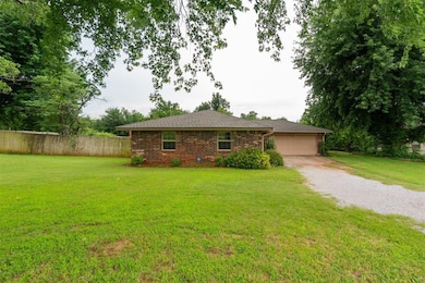 View of front of home with a garage, gravel driveway, brick siding, and roof with shingles