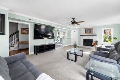 Living room with ceiling fan, carpet, crown moldin