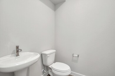 Step into this bright and airy half bath, where a