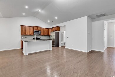 Kitchen featuring a center island with sink, stain