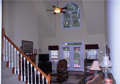 Two story den with fireplace and hardwood floors.