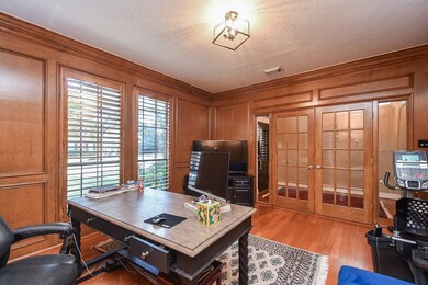 Large study with hardwood floors, rich wood paneli
