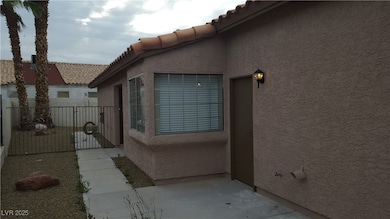 View of home's exterior with stucco siding, a gate