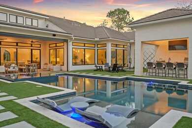 This backyard has everything you could want for entertaining and is completely artificial turf for low maintenance. A covered patio with automatic shade to keep you cool while acting as a screen while enjoying the sitting and dining area. On the other side of the pool and hot tub you will find a fire pit and covered outdoor kitchen.