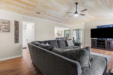 Living room featuring wood ceiling, a ceiling fan