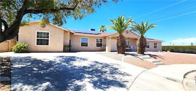 Ranch-style home with stucco siding, solar panels,