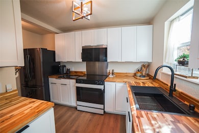 Kitchen with updated butcher block counters, recently installed soft close white cabinetry, and a new KRAUS sink and faucet. New Samsung smart range, and new Samsung refrigerator