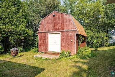 View of outdoor structure featuring a lawn