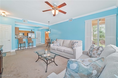 Carpeted living room with ceiling fan and crown mo