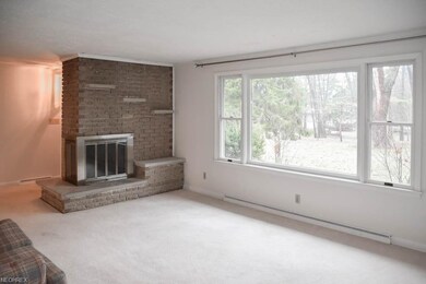 Living room with a picture window and a brick fire