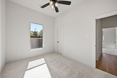 Unfurnished bedroom with carpet floors, multiple windows, and ceiling fan