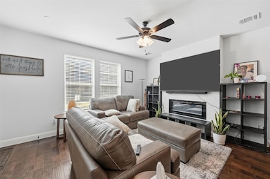 Living area with dark wood-type flooring and a ceiling fan
