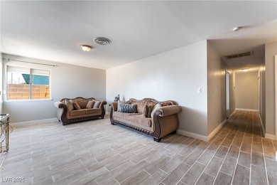 Living area with baseboards and light wood-style f