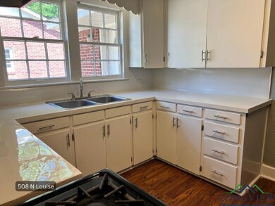 Kitchen featuring a sink, light countertops, white cabinets, and dark wood finished floors