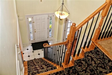 The foyer offers a custom staircase accented with 