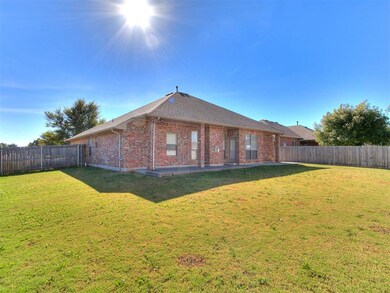 Back of house featuring brick siding, a fenced backyard, a patio, and a shingled roof