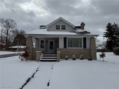 Bungalow-style house with brick siding, covered porch, and a chimney