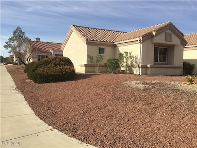 View of side of home with a tile roof and stucco s