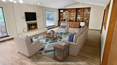Living room featuring a brick fireplace, light woo