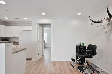 Workout room featuring crown molding, light wood-style flooring, and recessed lighting