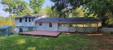 Rear view of house featuring a fenced backyard and a deck