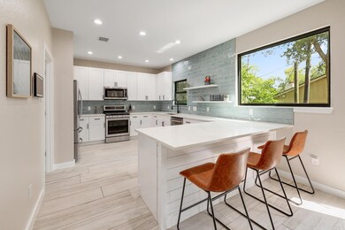 Kitchen featuring a breakfast bar, appliances wit