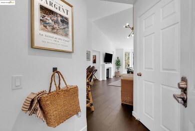 Hallway featuring dark wood-type flooring, a chandelier, and lofted ceiling