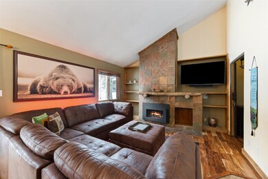 Living area with wood finished floors, vaulted cei