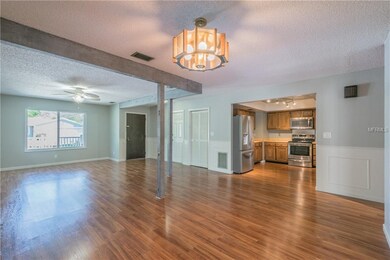 View of front door and kitchen from dining area.