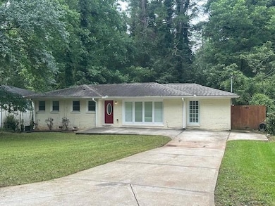 Ranch-style house featuring concrete driveway, brick siding, and roof with shingles