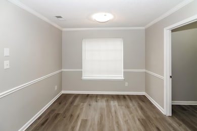Empty room with wood finished floors and ornamental molding