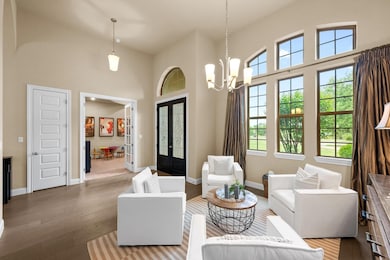 Living room with french doors, a high ceiling, wo