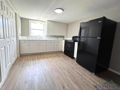 Kitchen featuring black appliances, light countert