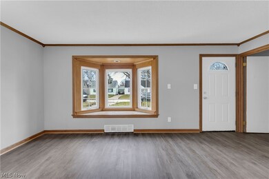 Entrance foyer featuring ornamental molding and wood-type flooring