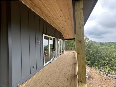 Deck with a forest view and covered porch