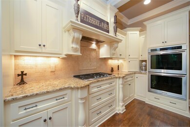 Commercial hood vent above 5-burner cooktop.