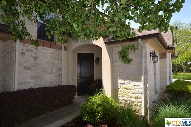 Covered entrance with stained large front door.