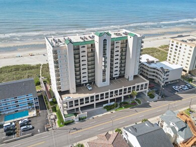 Aerial view of waterfront with a beach and apartment complex