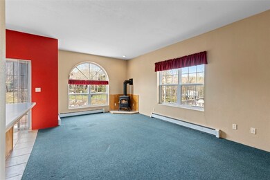 Carpeted empty room featuring baseboard heating an